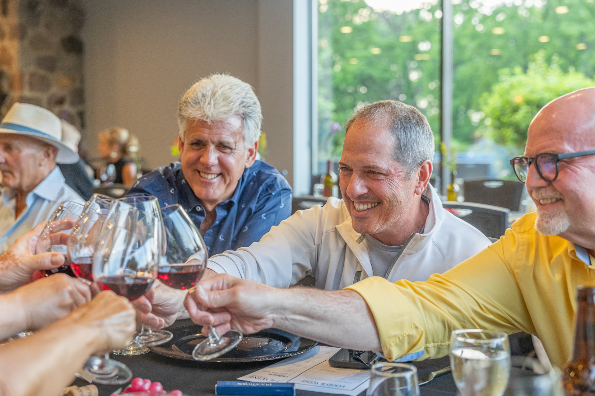 Guests toasting with red wine at the table